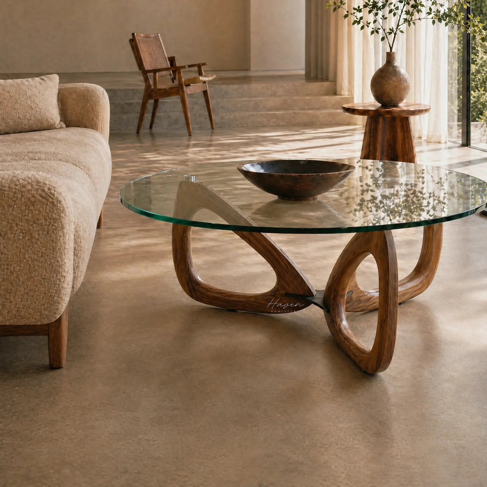 Maddox Mid Century Coffee Table with a sculptural ash base and glass top in a warm, neutral living room.