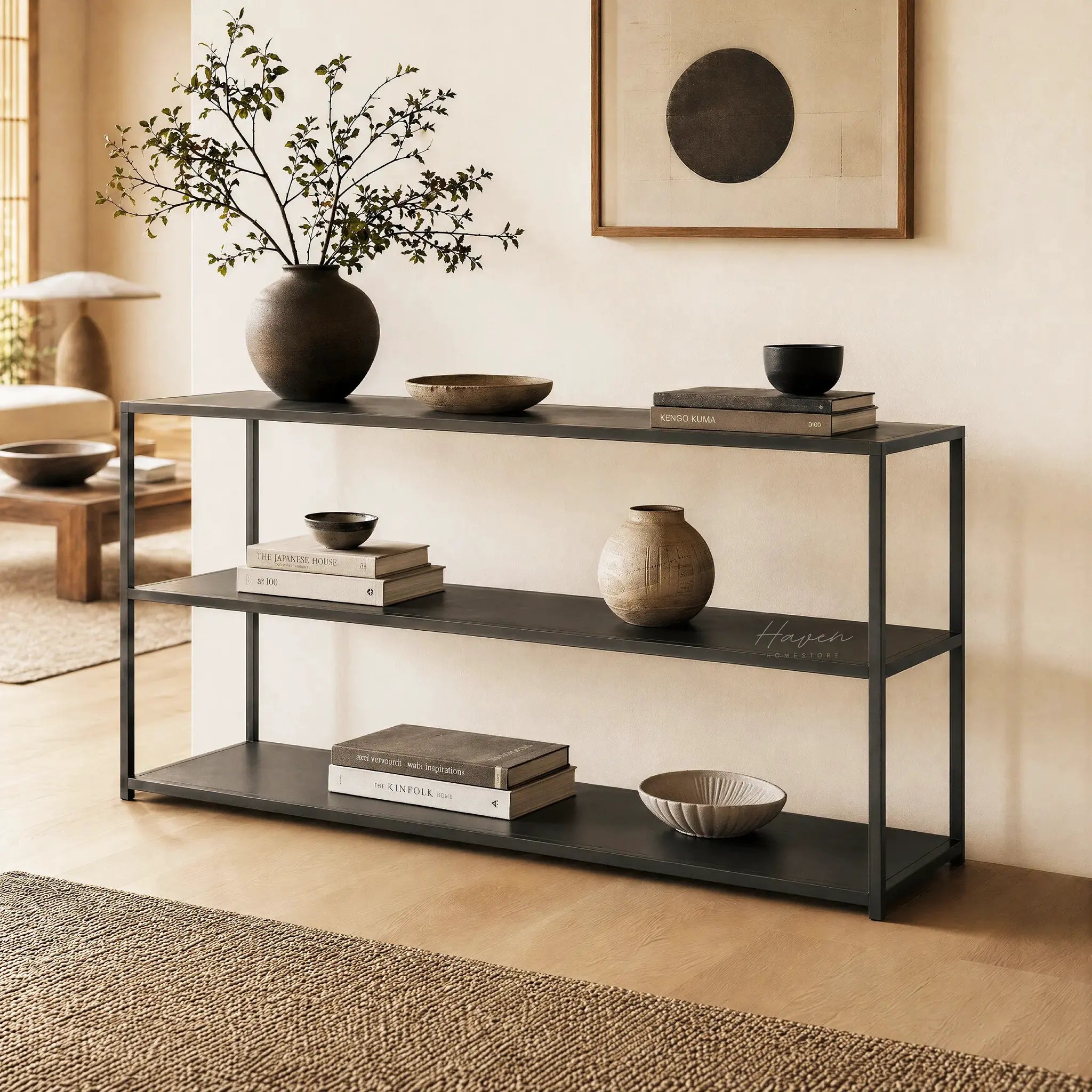 Studio Ellis Shelf: a low-profile black metal console with bowls, books, and a vase in a calm living space.