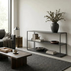Studio Ellis Shelf in a minimalist living room with a dark metal frame, books, and a vase of eucalyptus.
