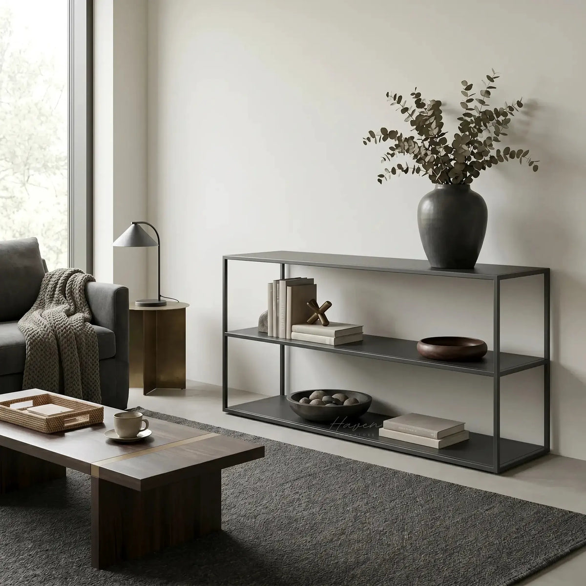 Studio Ellis Shelf in a minimalist living room with a dark metal frame, books, and a vase of eucalyptus.