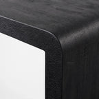 Clarence Waterfall Console in burnt wood resin finish, close-up of textured black surface and waterfall edge.