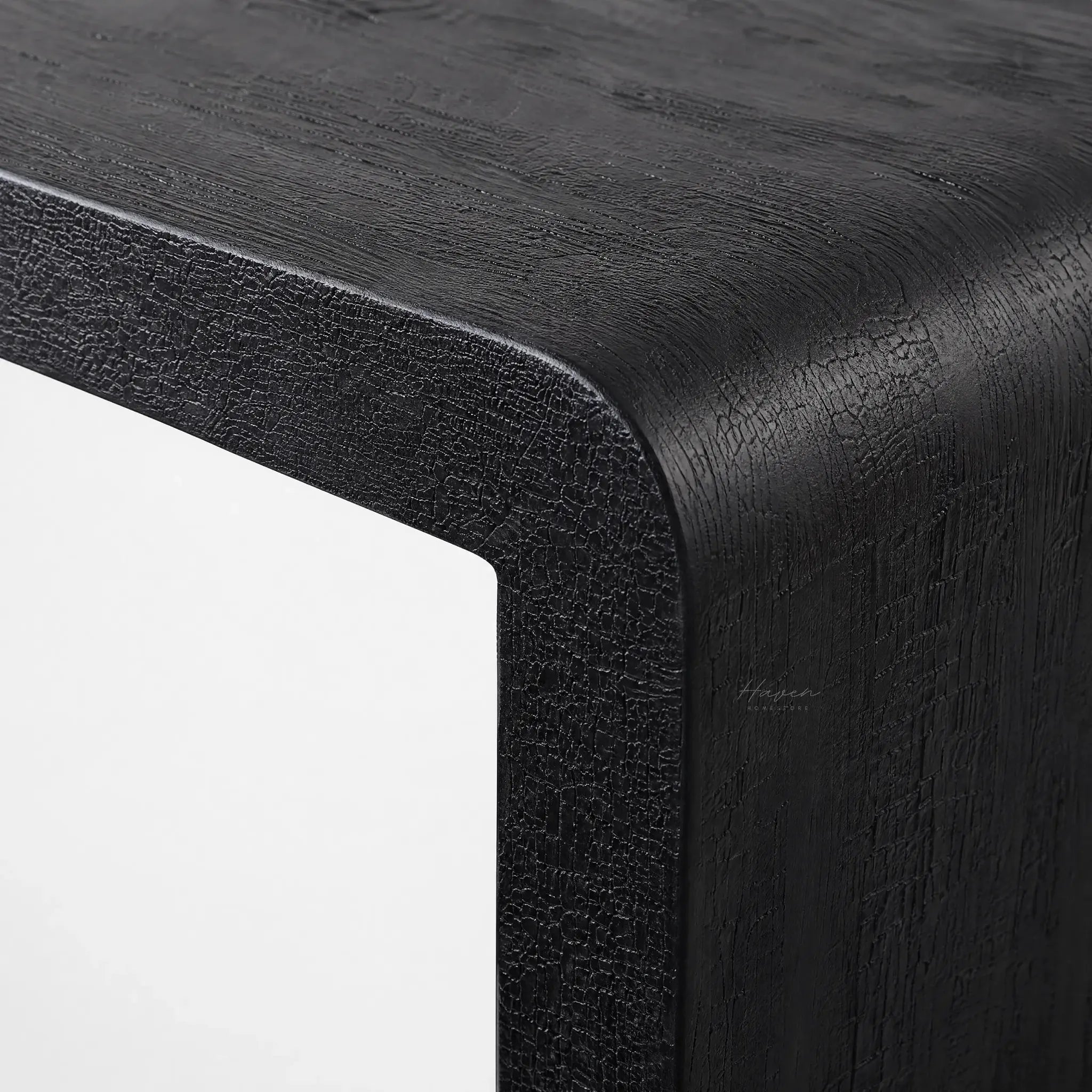 Clarence Waterfall Console in burnt wood resin finish, close-up of textured black surface and waterfall edge.
