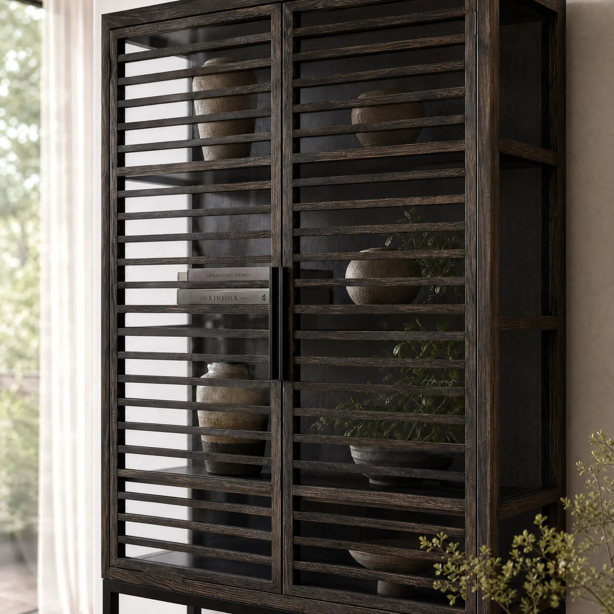 Kuro Slatted Cabinet in dark oak with glass panels behind slatted doors, showcasing decor inside.