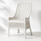 Albany Chair handwoven in natural rattan with a curved silhouette, warm texture in white setting.