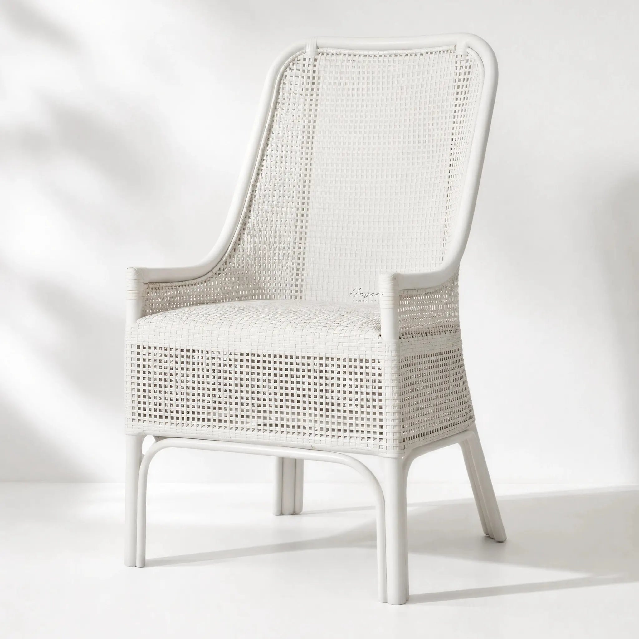 Albany Chair handwoven in natural rattan with a curved silhouette, warm texture in white setting.