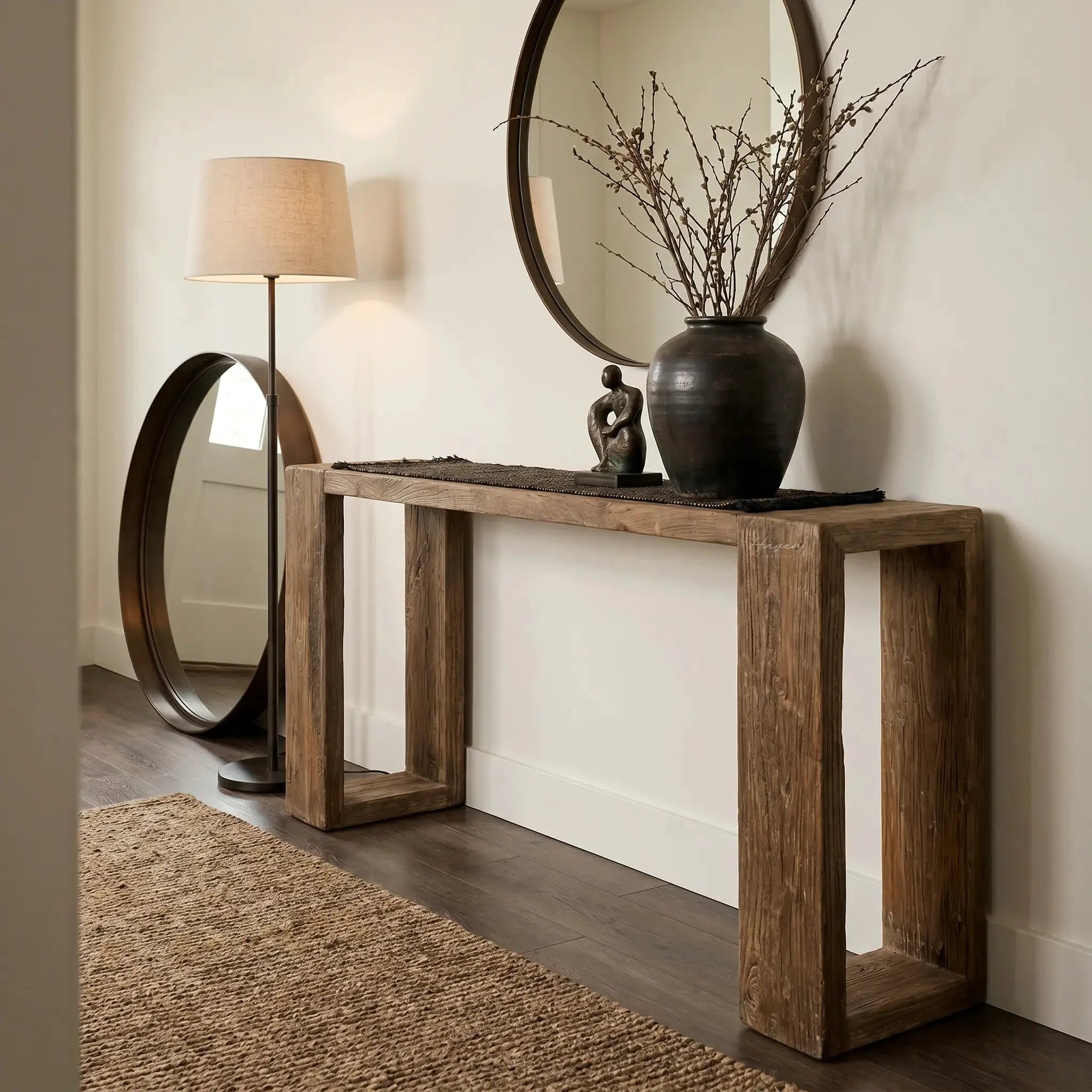 Casa Console in reclaimed elm with aged black wash, paired with a round mirror and twig vase in an entryway.