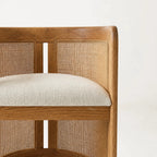 Cove Cane Chair with curved oak frame, woven rattan panels, and a cushioned seat.