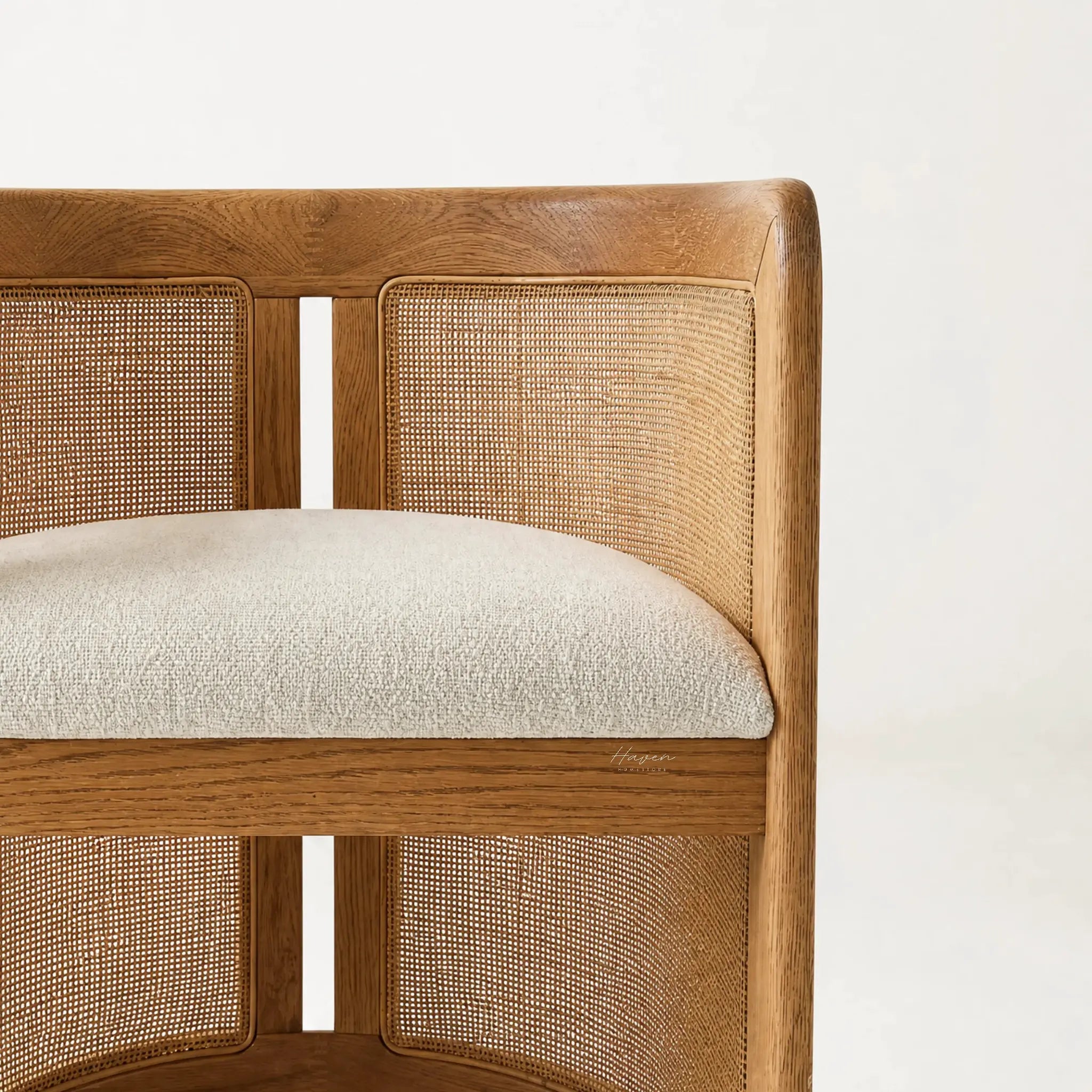 Cove Cane Chair with curved oak frame, woven rattan panels, and a cushioned seat.