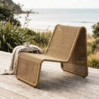 Marina outdoor lounge chair on a wooden coastal deck with woven rattan and ocean view.