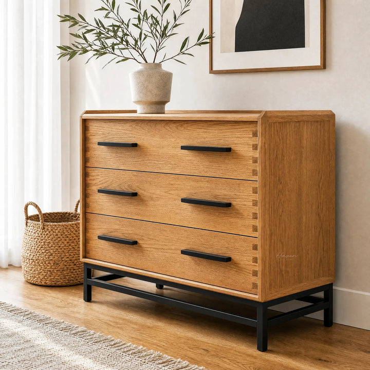 Cardrona 3 Drawer Dresser in oak veneer with black handles and a metal base, topped with a ceramic vase and greenery.
