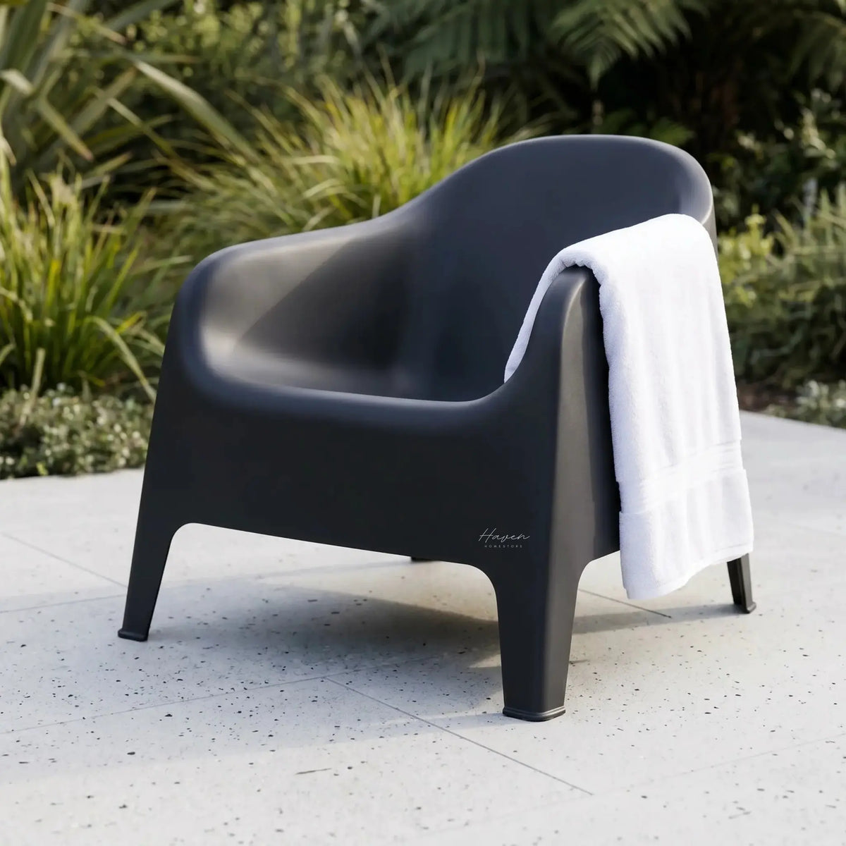 Eden Chair in dark gray polypropylene outdoors with a white towel draped over the back.
