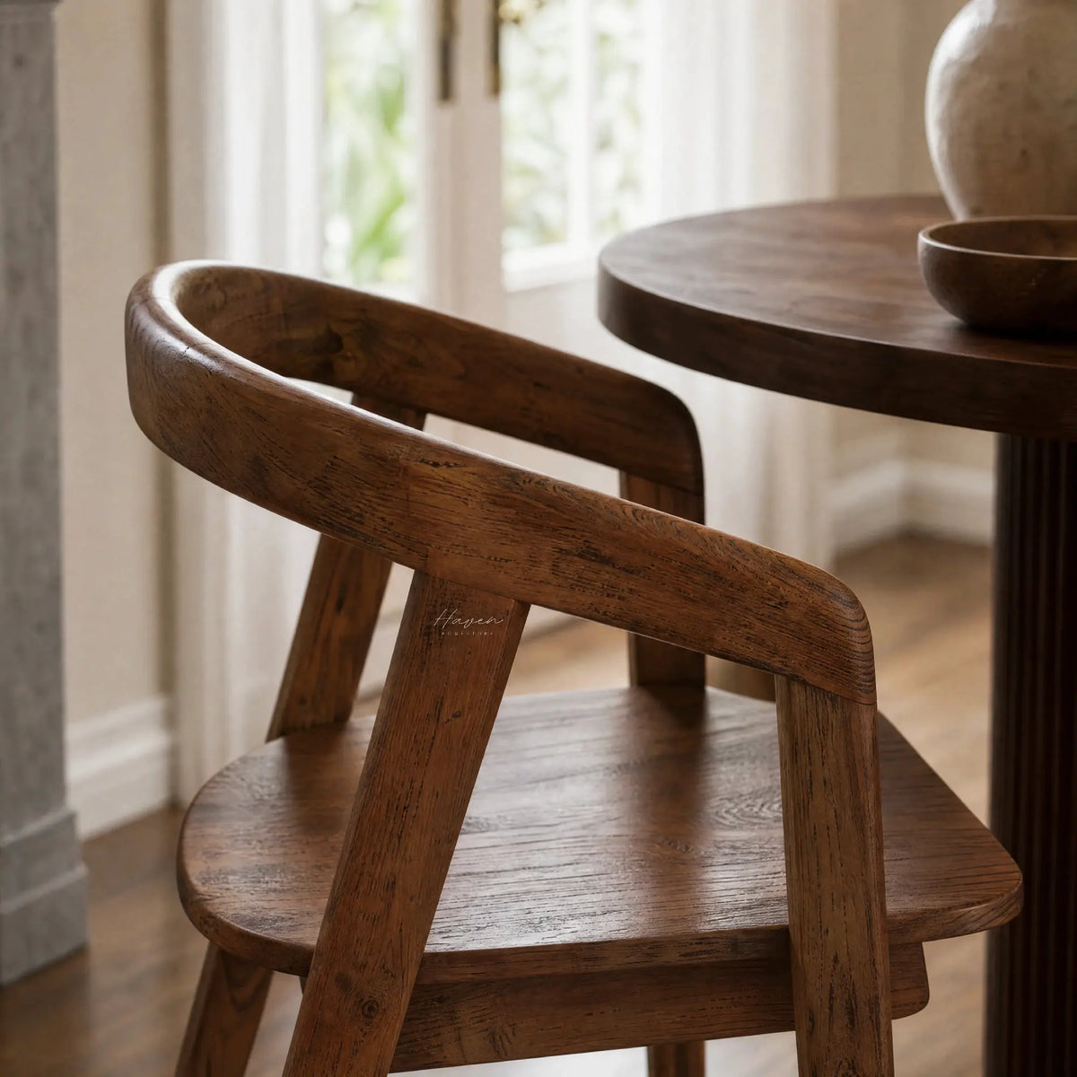 Dune Teak Dining Chair with sculptural form, curved arms, and warm solid teak.
