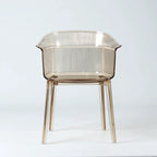 Translucent amber polycarbonate chair with sculptural wraparound silhouette and fine vertical texturing on back and seat.