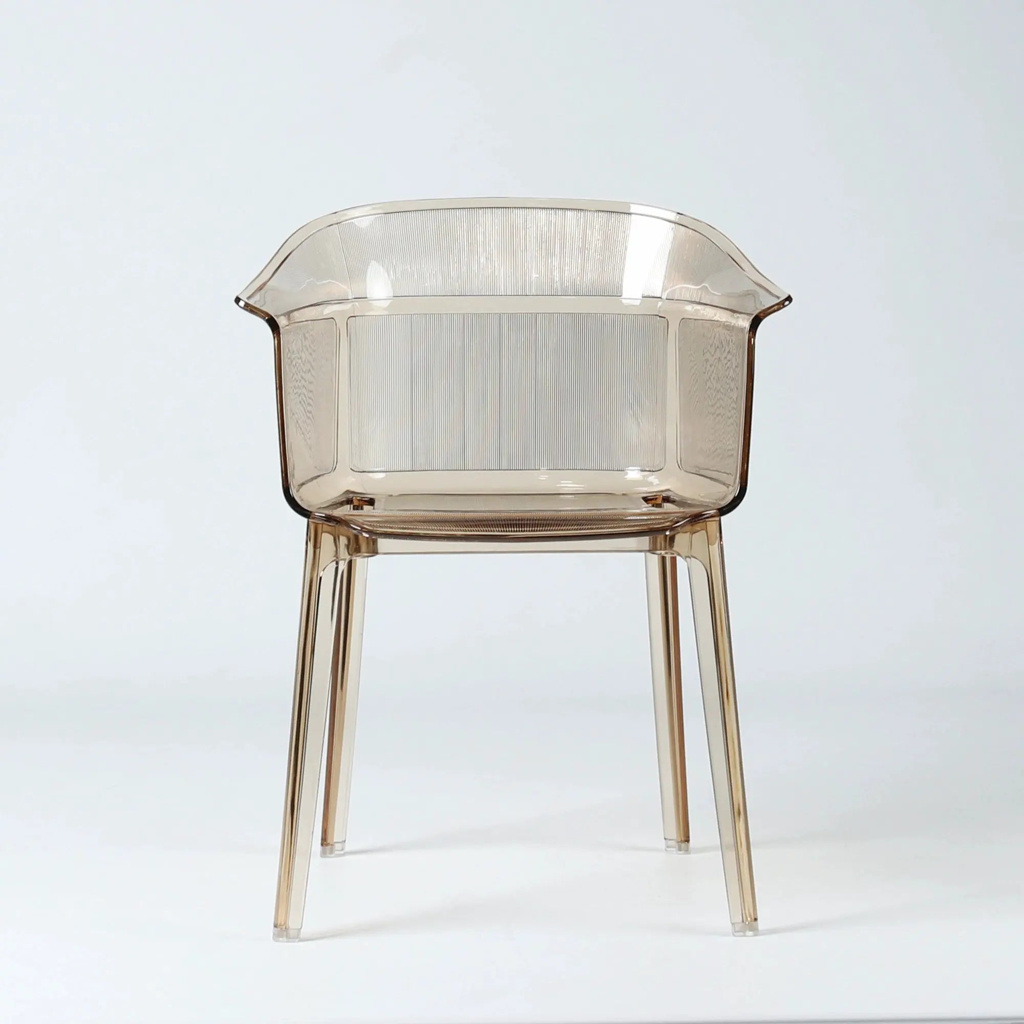 Translucent amber polycarbonate chair with sculptural wraparound silhouette and fine vertical texturing on back and seat.