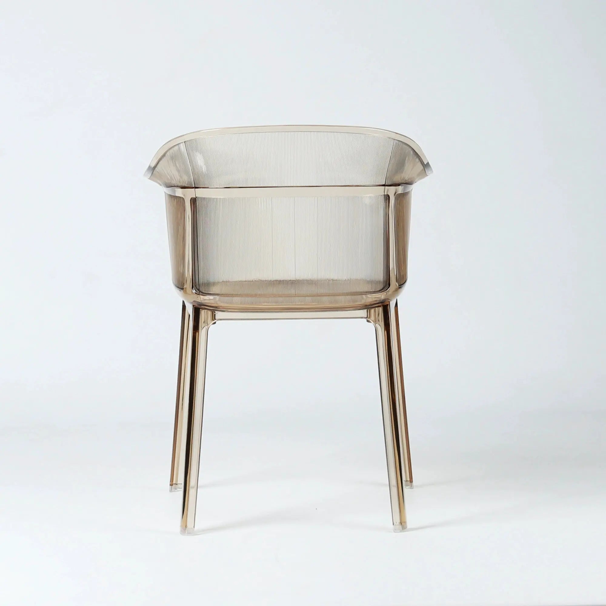 Translucent amber polycarbonate chair with sculptural wraparound silhouette and fine vertical detailing on back and seat.