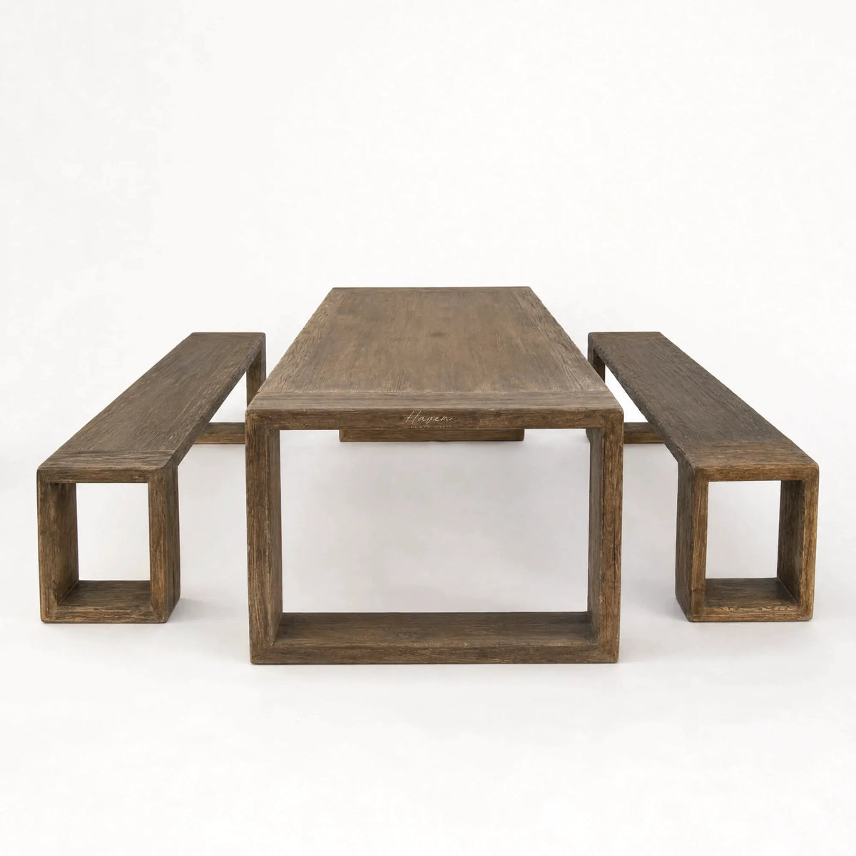 Reclaimed elm Estuary dining table with matching benches featuring bold geometric bases and rich, weathered grain.