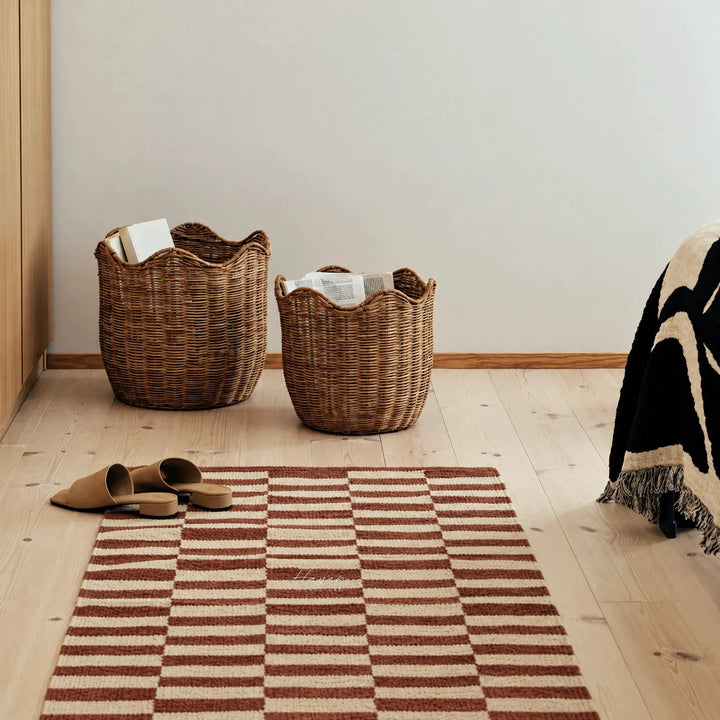 Mocha bisque and oatmeal geometric rug runner on wood floor beside wicker baskets and tan mules.