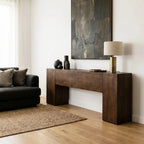 Plinth Console in reclaimed elm with rich grain and architectural silhouette, set in a contemporary living room.