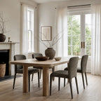 Textured lichen dining chairs with rounded backs surround a natural wood table in a bright room with sheer curtains.