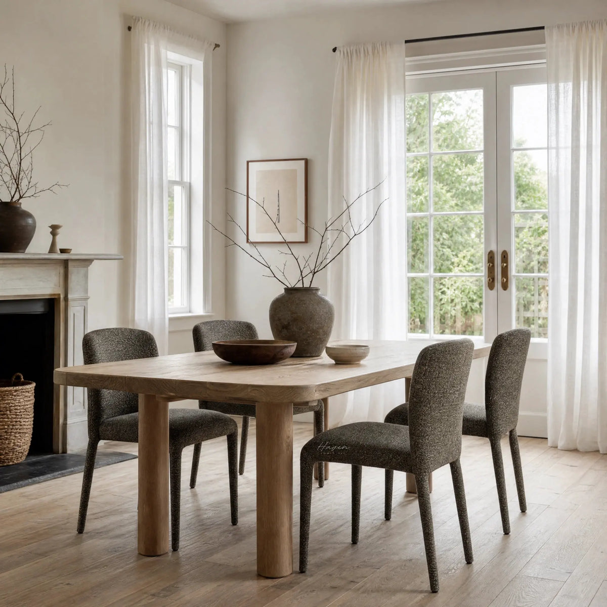 Textured lichen dining chairs with rounded backs surround a natural wood table in a bright room with sheer curtains.