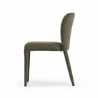Side profile of a lichen green dining chair with textured upholstery, rounded back, and slender profile.