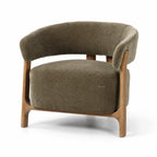 Noma Lounge Chair in olive with curved back, textured upholstery, and exposed ash wood frame.