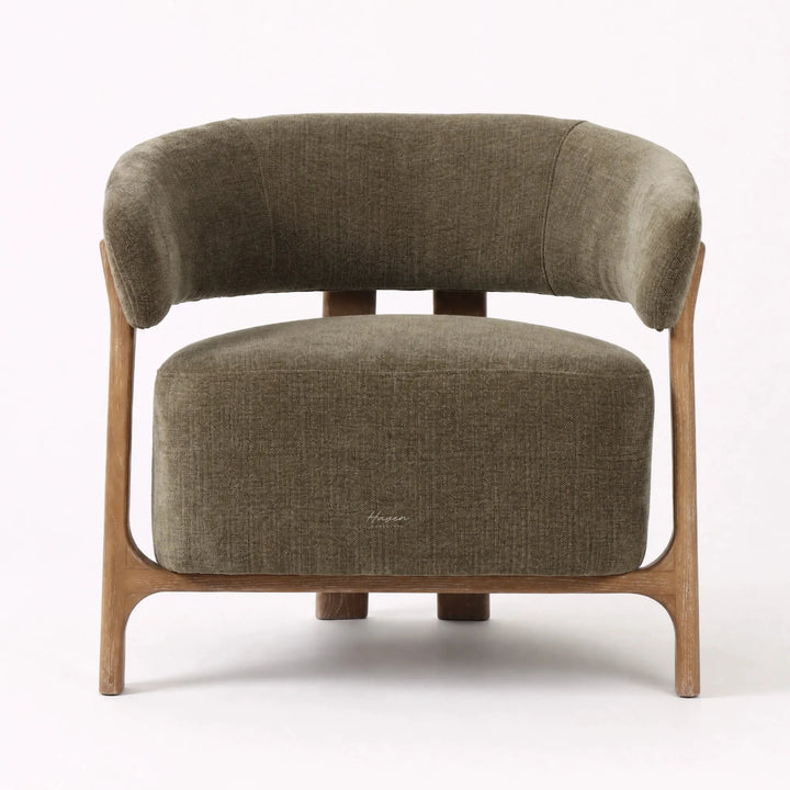 Curved olive lounge chair with textured neutral upholstery and exposed ash wood frame.