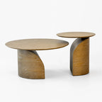 Sculptural solid ash coffee table duo featuring slim circular tops and sweeping curved pedestal bases for natural warmth.