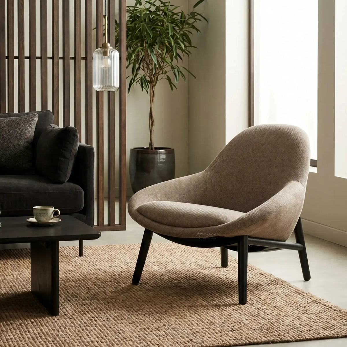 Pierre Chair - Latte in a modern living room with a dark sofa, wooden slat divider, and a potted plant.