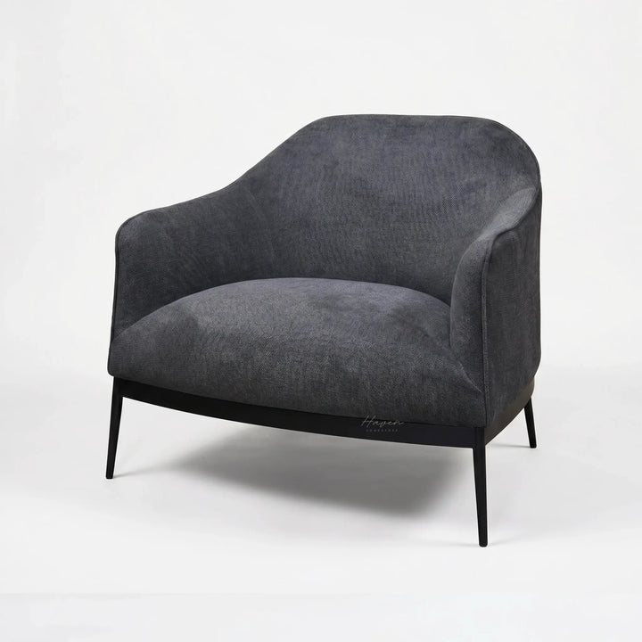 The Sydney Chair features soft textured, 100% recycled polyester upholstery, curved back, and slim black legs.