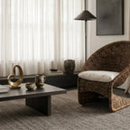 Scoop Chair with handwoven water hyacinth rope and cushioned seat and back for lounging in a serene living space.