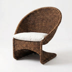 Scoop Chair in brown handwoven water hyacinth rope with white cushions for lounging.