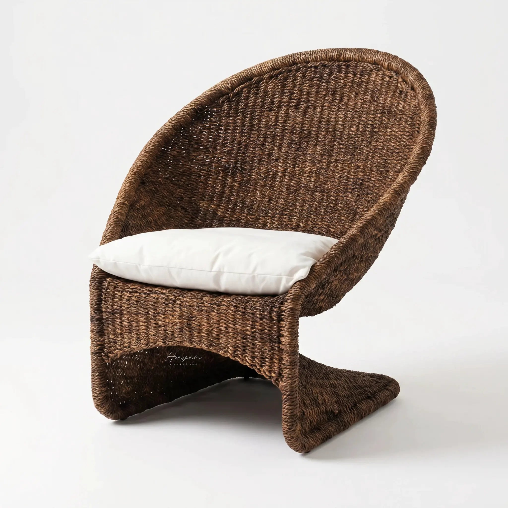 Scoop Chair in brown handwoven water hyacinth rope with white cushions for lounging.