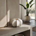 White sculptural Suzu vase made of fine bone china sitting on concrete table.