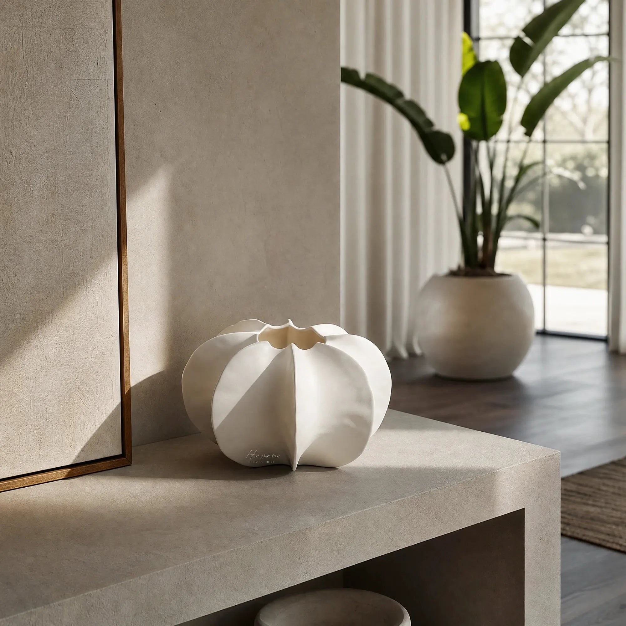 White sculptural Suzu vase made of fine bone china sitting on concrete table.