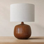 Aksel Table Lamp in umber glazed ribbed ceramic with linen shade on wood side table