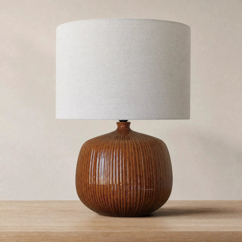 Aksel Table Lamp in umber glazed ribbed ceramic with linen shade on wood side table