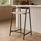 Scandinavian counter stool with natural ash seat and slim black iron frame featuring padded leather backrest for kitchen seating.